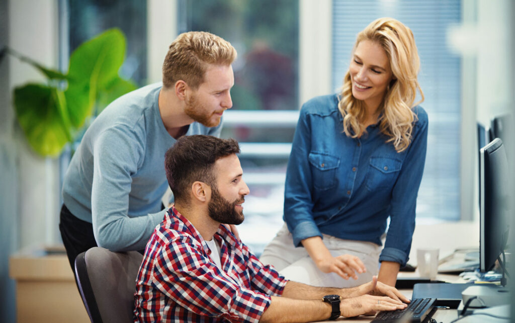 Zwei Herren und eine Dame unterhalten sich am Arbeitsplatz